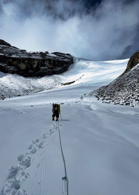 Berglandschaft mit schneebedecktem Gletscher und Fußspuren im Schnee.