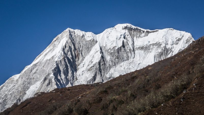 Schneebedeckte Bergspitze unter einem klaren blauen Himmel.