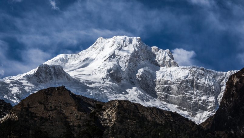 Schneebedeckter Gipfel eines majestätischen Berges unter einem klaren blauen Himmel.