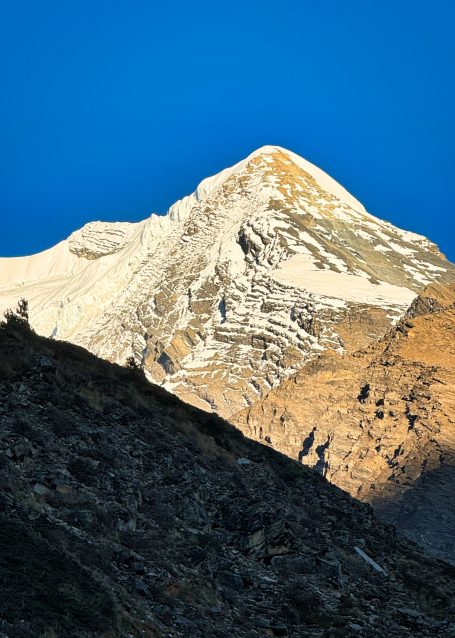 Schneebedeckter Berggipfel unter klarem blauen Himmel.