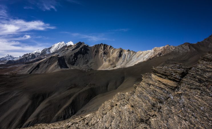 Gebirgskette mit Felsen und tiefblauem Himmel im Hintergrund.