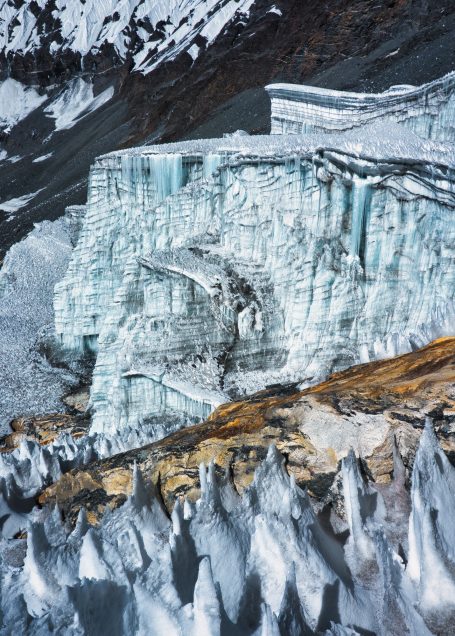 Eisige Gletscherlandschaft mit schroffen Felsen und tiefen Spalten.