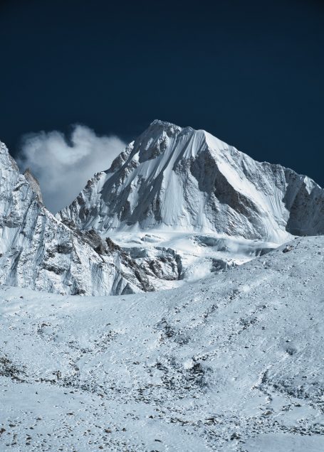 Hoher, schneebedeckter Berggipfel unter klarem, blauem Himmel.