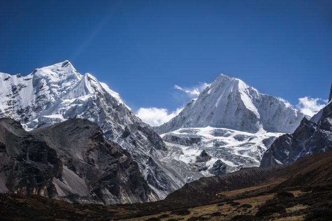 Hohe, schneebedeckte Berge unter klarem blauen Himmel.