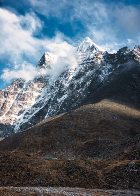 Schneebedeckte Berge unter einem bewölkten Himmel mit leichtem Nebel.