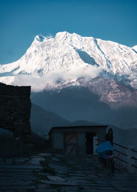 Berglandschaft mit schneebedecktem Gipfel und Nebel über dem Tal.