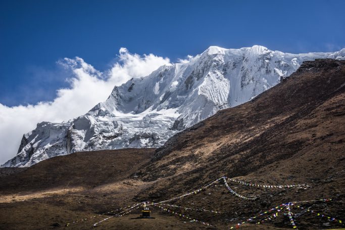 Schneebedeckte Berge unter einem klaren blauen Himmel mit Wolken.