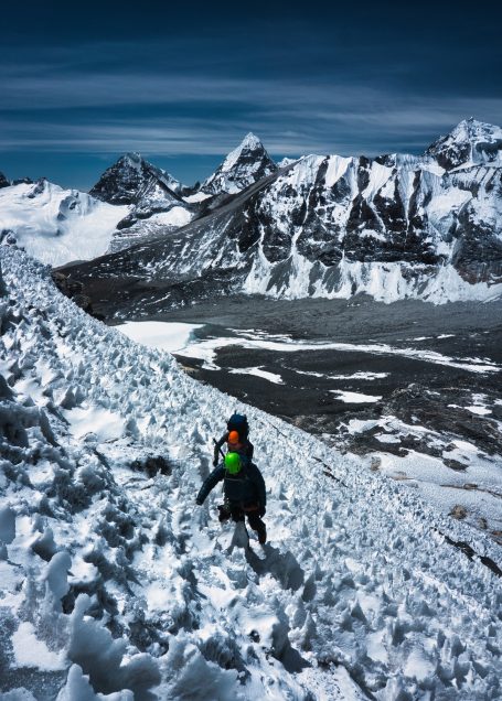 Bergsteiger auf schneebedecktem Hang mit beeindruckendem Gebirgshorizont im Hintergrund.