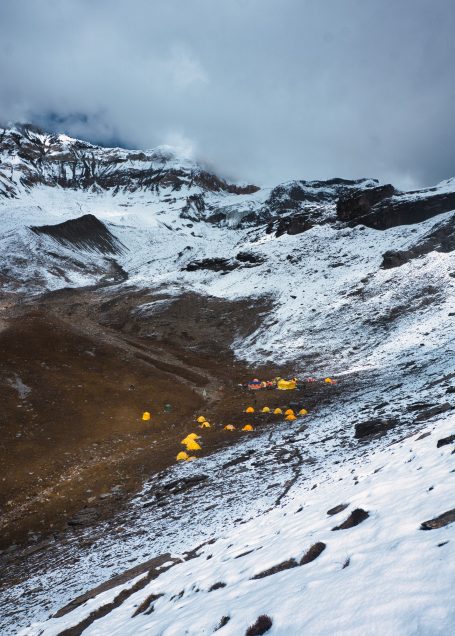Schneebedeckte Landschaft mit orangefarbenen Lichtpunkten in der Ferne.