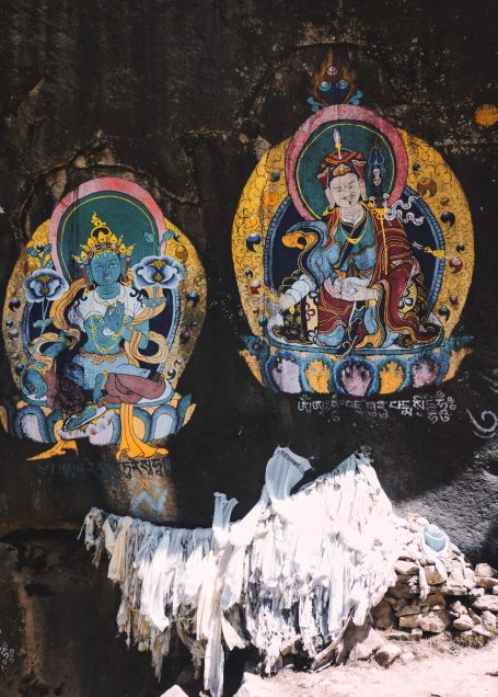 Bunte Wandmalereien von Gottheiten in traditioneller Kunstdarstellung.