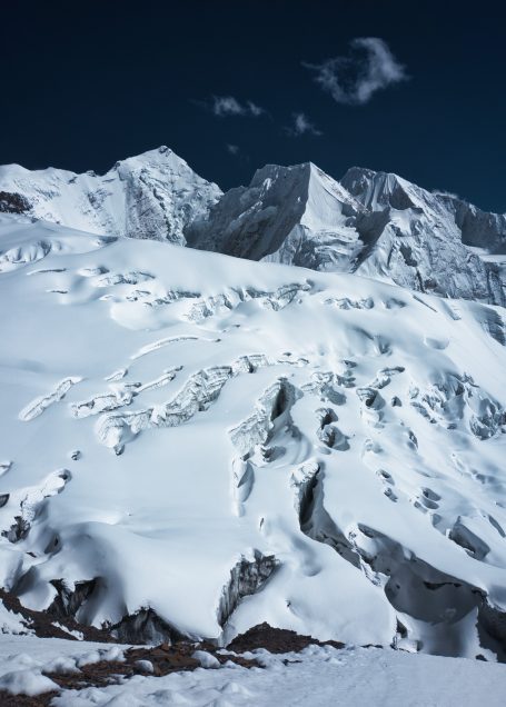 Hohe, schneebedeckte Berge unter einem klaren, blauen Himmel.