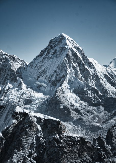 Hohe schneebedeckte Bergspitze vor klarem, blauem Himmel.