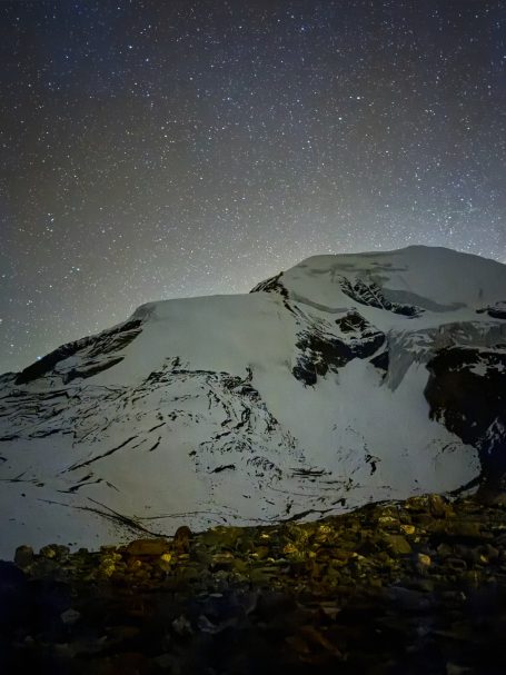 Schneebedeckter Berg unter einem sternklaren Nachthimmel.