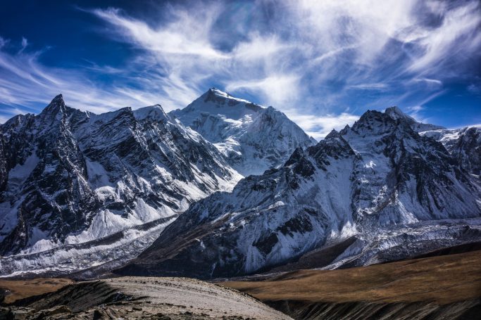 Schneebedeckte Berge unter einem blauen Himmel mit Wolken.