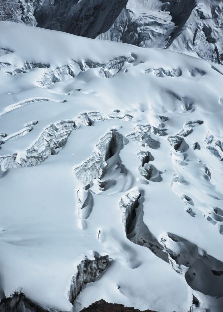 Schneebedeckte Berglandschaft mit Rissen im Gletscher.