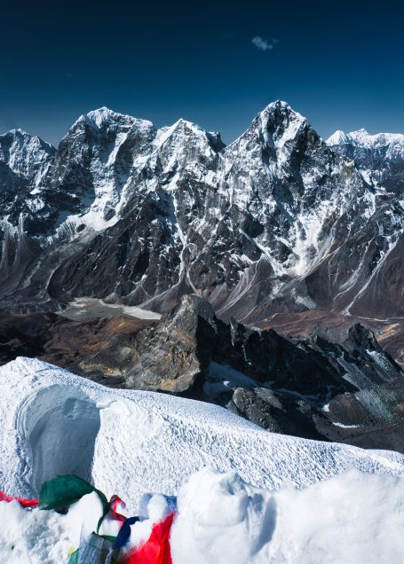 Schneebedeckte Berge unter klarem Himmel mit schneebedecktem Tal im Vordergrund.