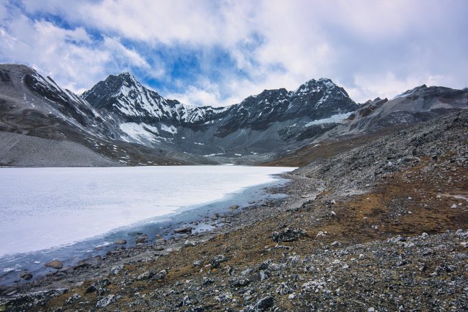 Berglandschaft mit schneebedeckten Gipfeln und einem gefrorenen See.