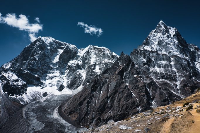 Hohe, schneebedeckte Berge unter einem klaren blauen Himmel.