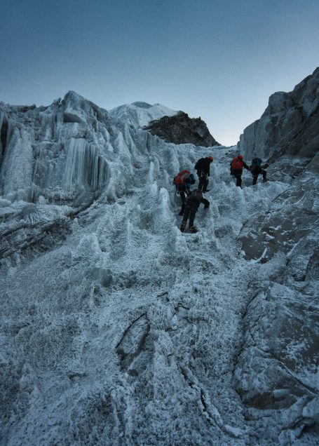 Bergsteiger klettern auf einer eisigen Gletscheroberfläche in den Alpen.