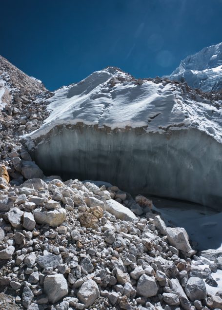 Eisige Gletscherlandschaft mit felsigen Grundlagen und klarem, blauem Himmel.