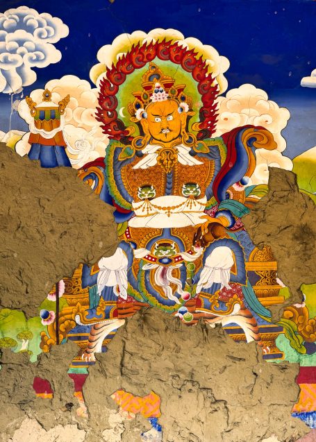 Buddhistische Wandmalerei mit mächtiger Gottheit und farbenfrohen Details.