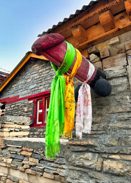 Bunte Tücher an einem Steinmauer, die eine traditionelle Dekoration darstellen.