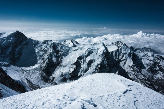 Schneebedeckte Berge unter einem klaren blauen Himmel.