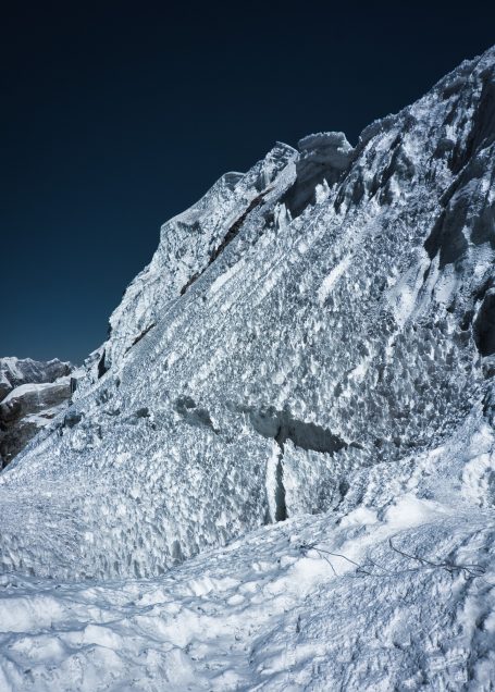 Gletscherlandschaft mit schneebedeckten Felsen und klarem, blauem Himmel.