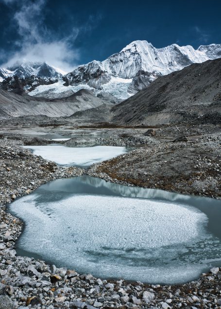 Hochgebirgslandschaft mit gefrorenen Seen und schneebedeckten Bergen.