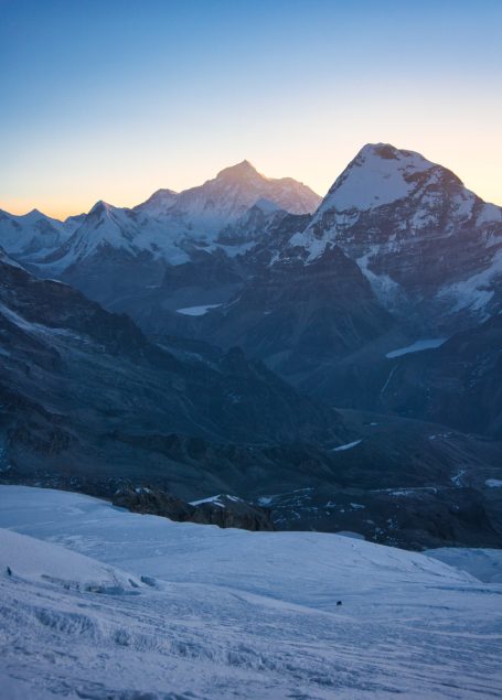Schneebedeckte Berge im Sonnenaufgang mit sanften Hängen und klarer Sicht.